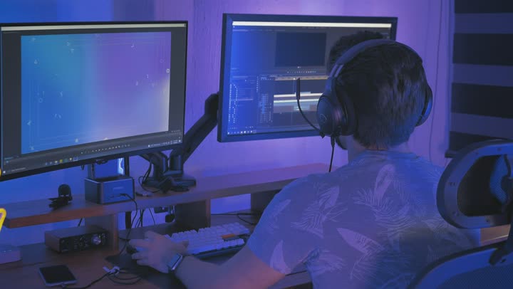 A video editor at two monitors